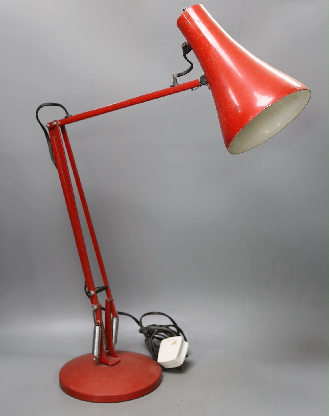 A red anglepoise desk lamp